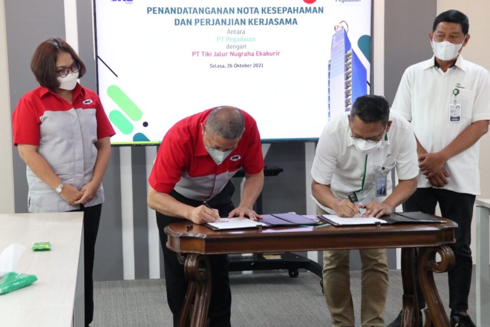 Direktur Utama Pegadaian, Kuwiyoto dan President Director JNE, Mohamad Feriadi menandatangani MoU (foto/istimewa)